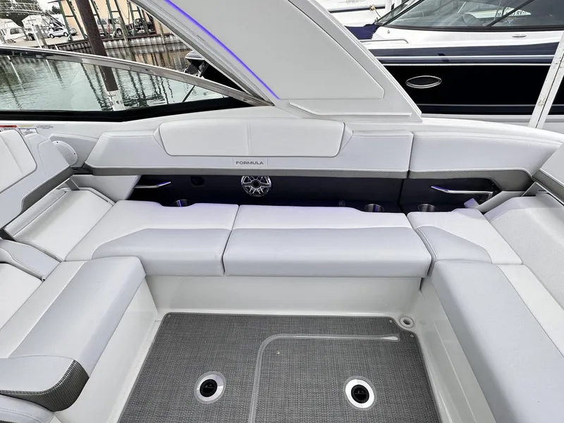 Slide: The Image of 2024 Formula 310 Bowrider I/O interior seating area with open storage compartment. - 24