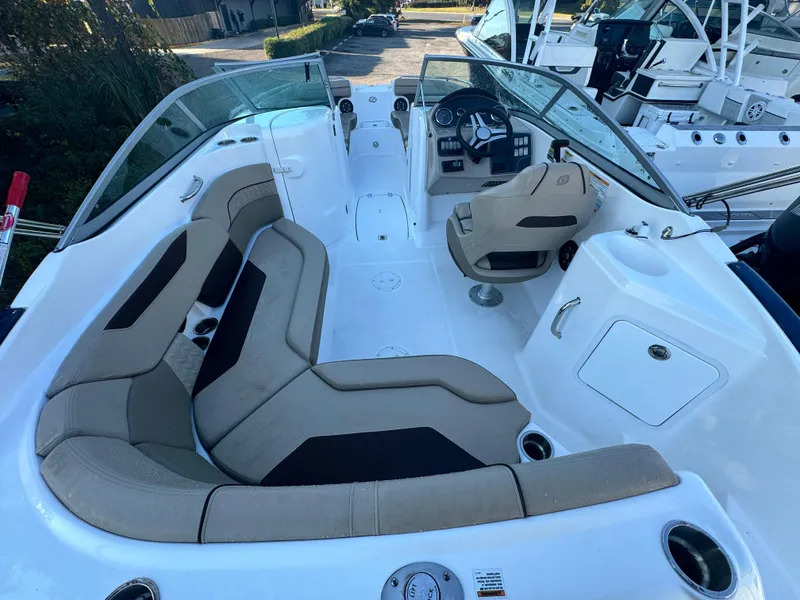 Slide: The Image of 2023 Hurricane SunDeck 2200 DC OB boat interior with beige seating and steering console. - 11