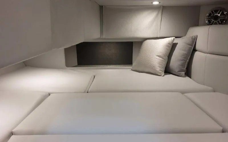 Slide: The Image of 2025 Formula 330 Crossover Bowrider I/O cabin interior with plush seating and cushions. - 11