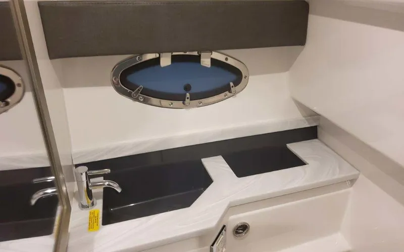 Slide: The Image of 2025 Formula 330 Crossover Bowrider I/O bathroom with sleek sink and oval window. - 20