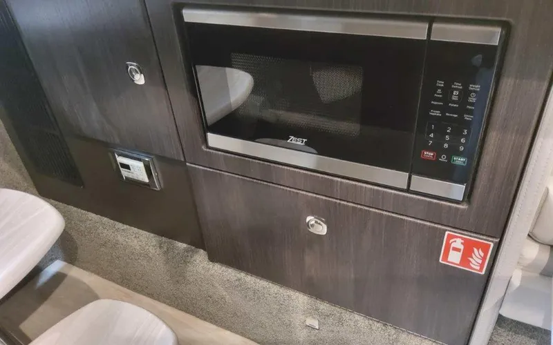 Slide: The Image of 2025 Formula 330 Crossover Bowrider I/O interior with microwave and cabinetry. - 21