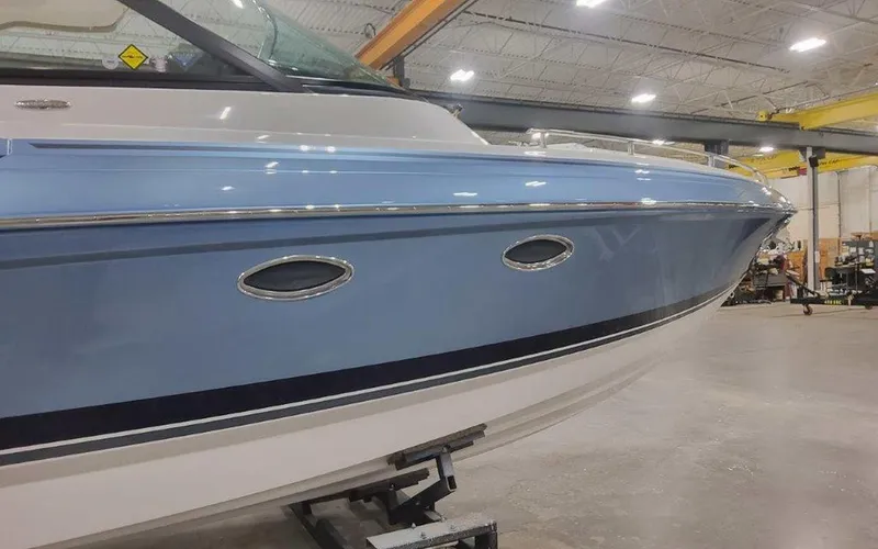 Slide: The Image of 2025 Formula 330 Crossover Bowrider I/O in a showroom, showcasing sleek blue hull design. - 6