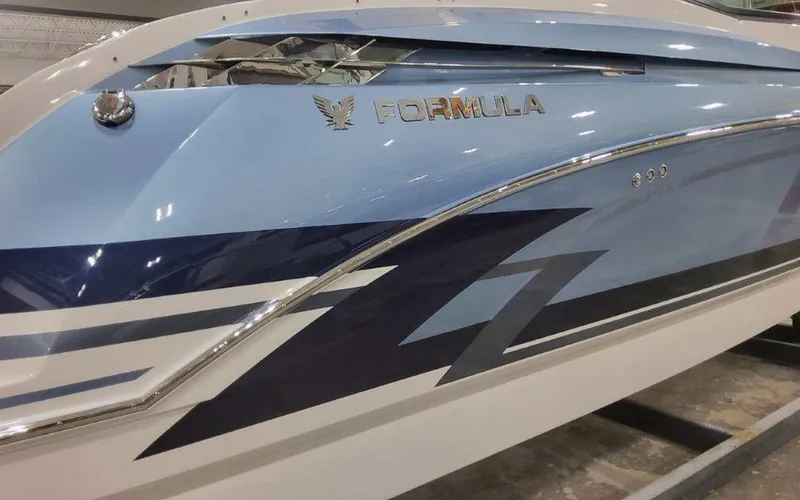 Slide: The Image of 2025 Formula 330 Crossover Bowrider I/O boat with sleek blue and white design. - 2