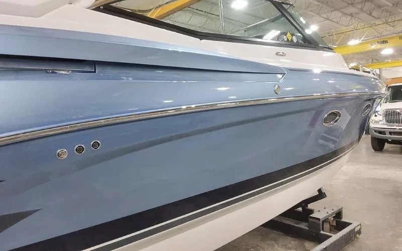 Slide: The Image of 2025 Formula 330 Crossover Bowrider I/O in a showroom, showcasing sleek blue exterior design. - 5