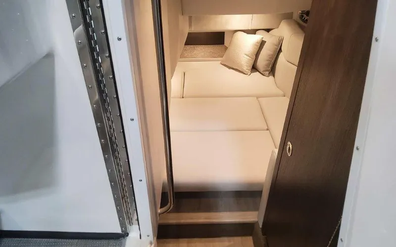 Slide: The Image of 2025 Formula 330 Crossover Bowrider I/O cabin interior with cozy bedding and cushions. - 9