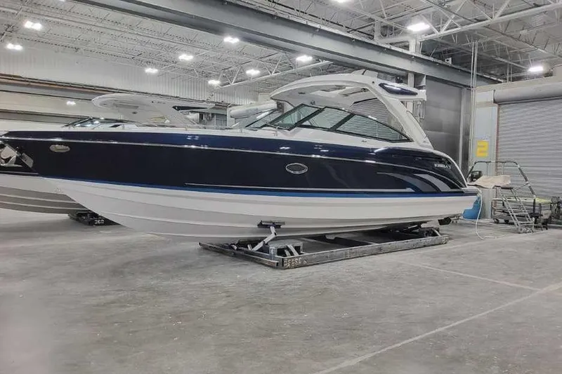 The Image of 2027 Formula 330 Crossover Bowrider I/O in a showroom, sleek design, blue and white exterior. - 0