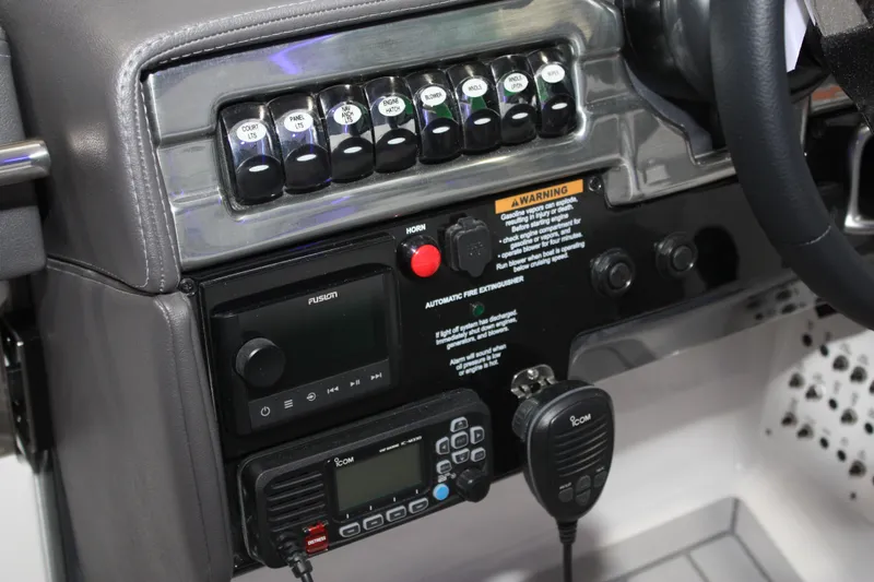 Slide: The Image of Control panel of a 2027 Formula 330 Crossover Bowrider I/O boat with switches and radio. - 55