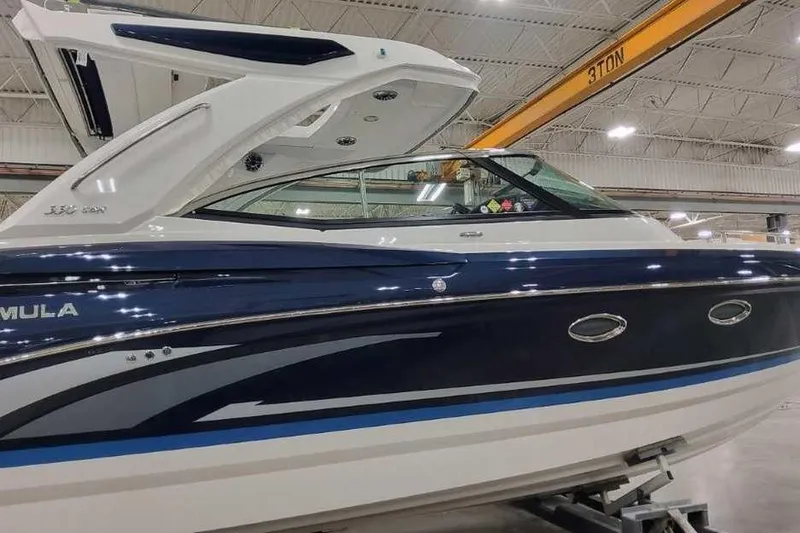 Slide: The Image of 2027 Formula 330 Crossover Bowrider I/O in showroom, sleek design, blue and white exterior. - 3