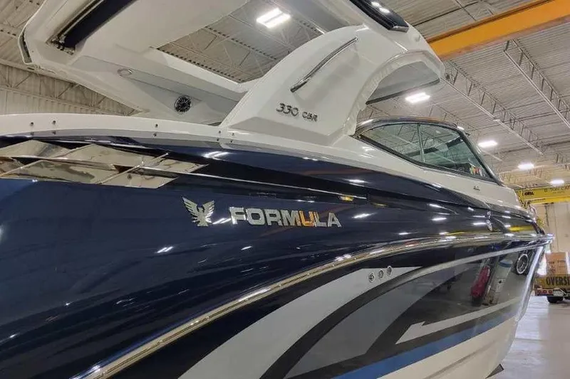 Slide: The Image of 2027 Formula 330 Crossover Bowrider I/O in showroom, showcasing sleek design and branding. - 2