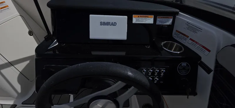 Slide: The Image of 2025 Sea Ray SPX 190 dashboard with Simrad display and steering wheel. - 7