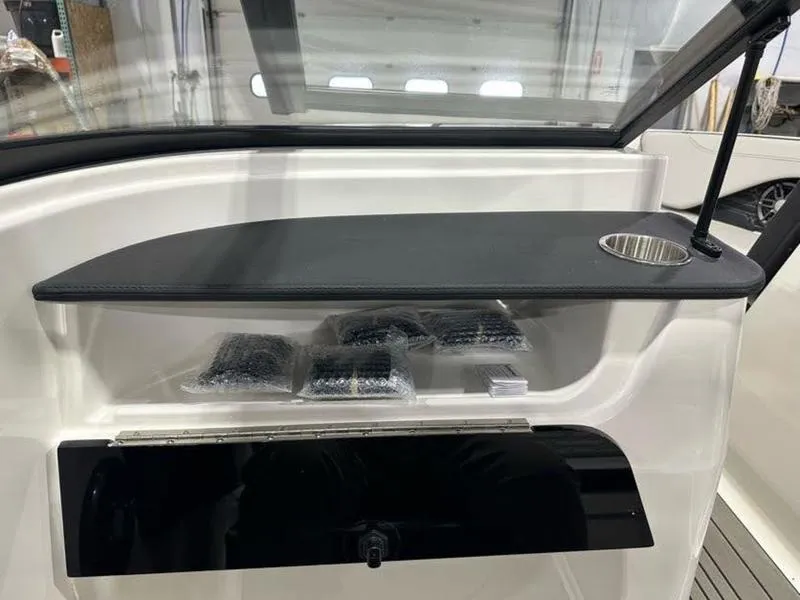 Slide: The Image of 2025 Sea Ray SPX 190 OB boat interior with storage and cup holder. - 12