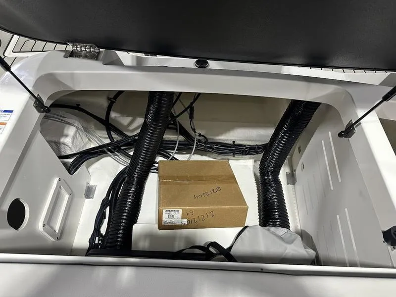Slide: The Image of Storage compartment of 2025 Sea Ray SPX 190 OB boat with cables and a cardboard box. - 18