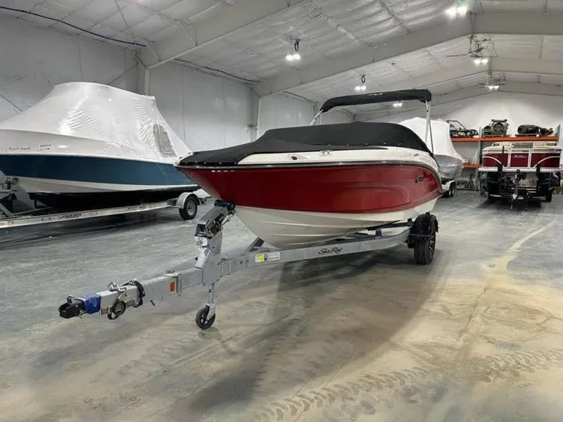 Slide: The Image of 2025 Sea Ray SPX 190 OB boat in indoor storage, red hull, covered, on trailer. - 3