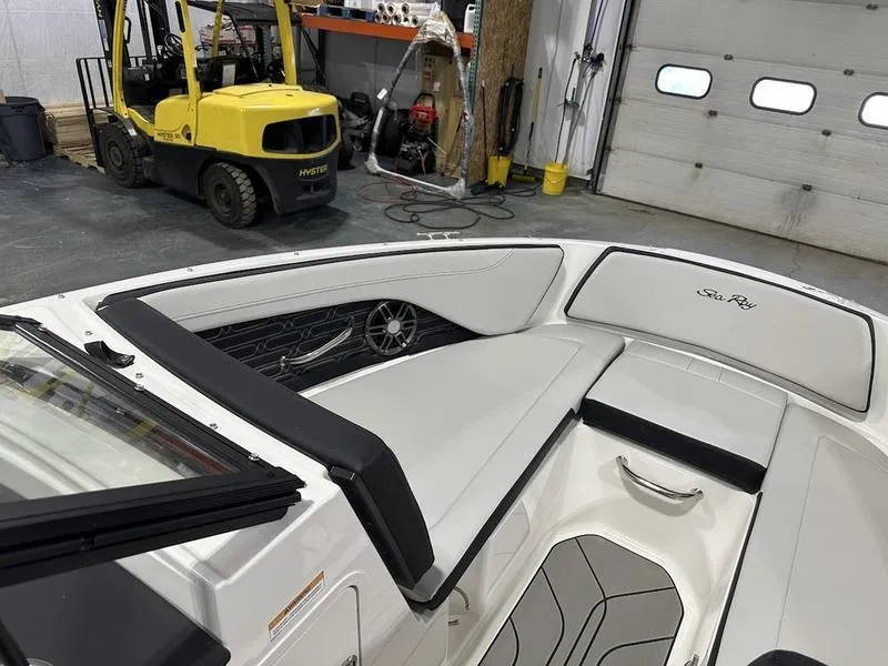 Slide: The Image of 2025 Sea Ray SPX 190 OB boat interior in a garage with a forklift nearby. - 8