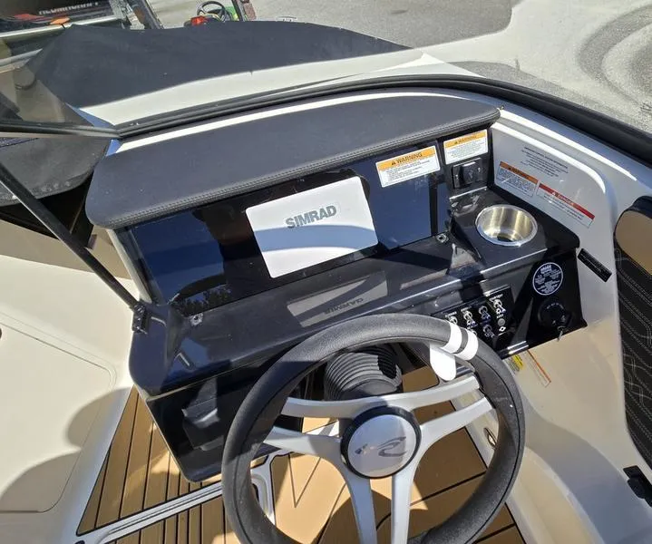Slide: The Image of 2025 Sea Ray SPX 210 boat dashboard with steering wheel and Simrad display. - 5