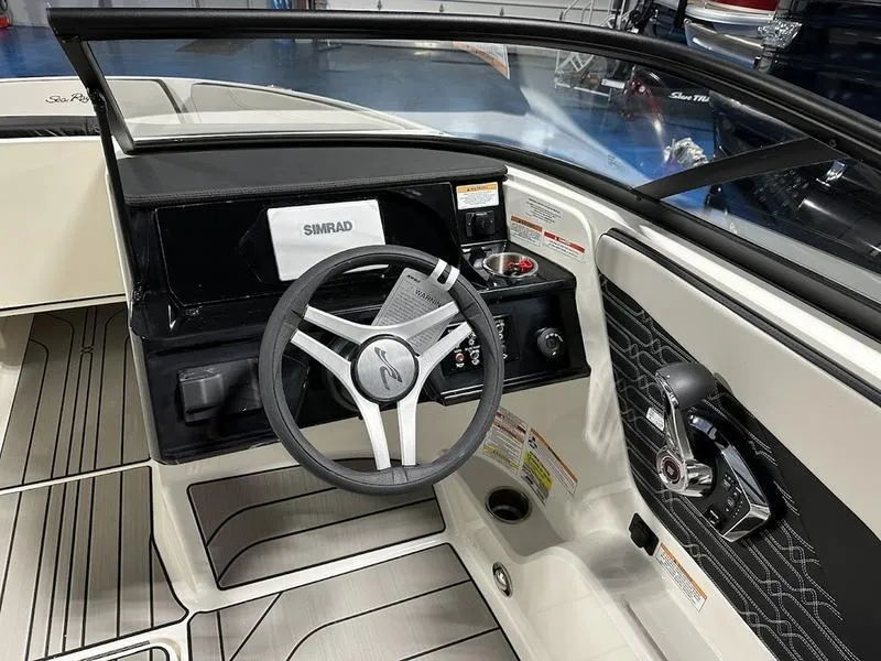 Slide: The Image of 2025 Sea Ray SPX 210 OB boat cockpit with steering wheel and control panel. - 10
