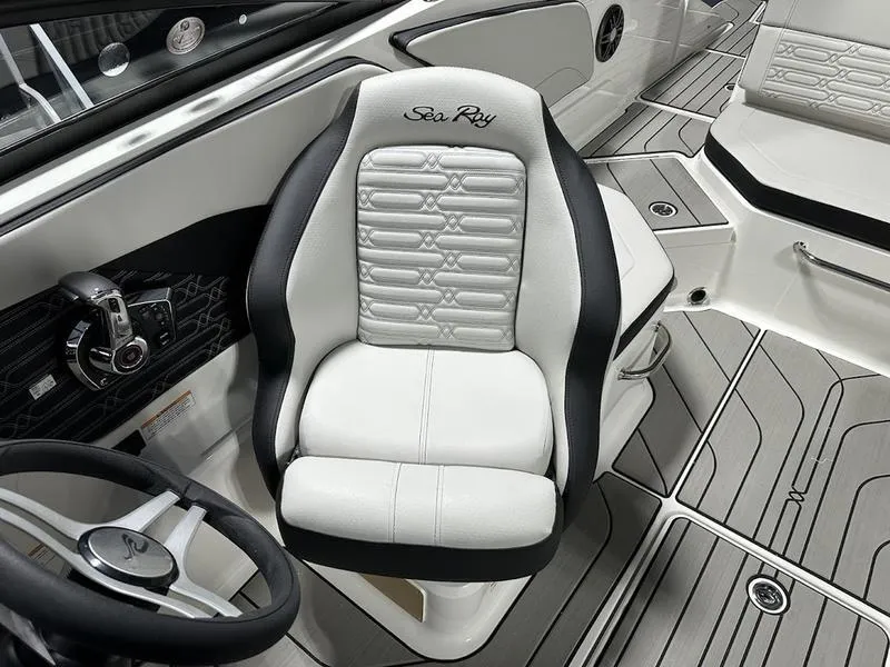 Slide: The Image of 2025 Sea Ray SPX 210 OB boat interior with sleek captain's chair and modern dashboard. - 2