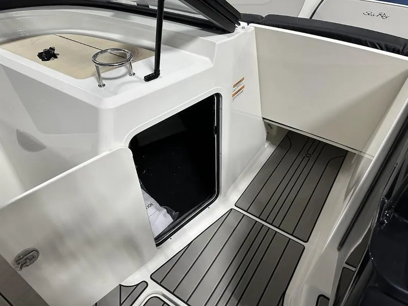 Slide: The Image of 2025 Sea Ray SPX 210 OB boat interior with open storage compartment and sleek flooring. - 7