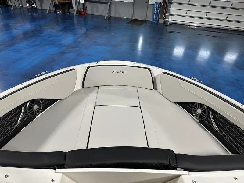 Slide: The Image of 2025 Sea Ray SPX 210 OB boat interior with white seating in a showroom. - 9