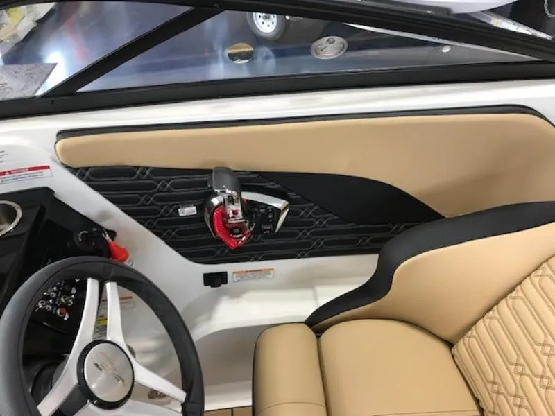 Slide: The Image of 2025 Sea Ray SPX 210 OB interior with beige seating and modern steering wheel. - 10