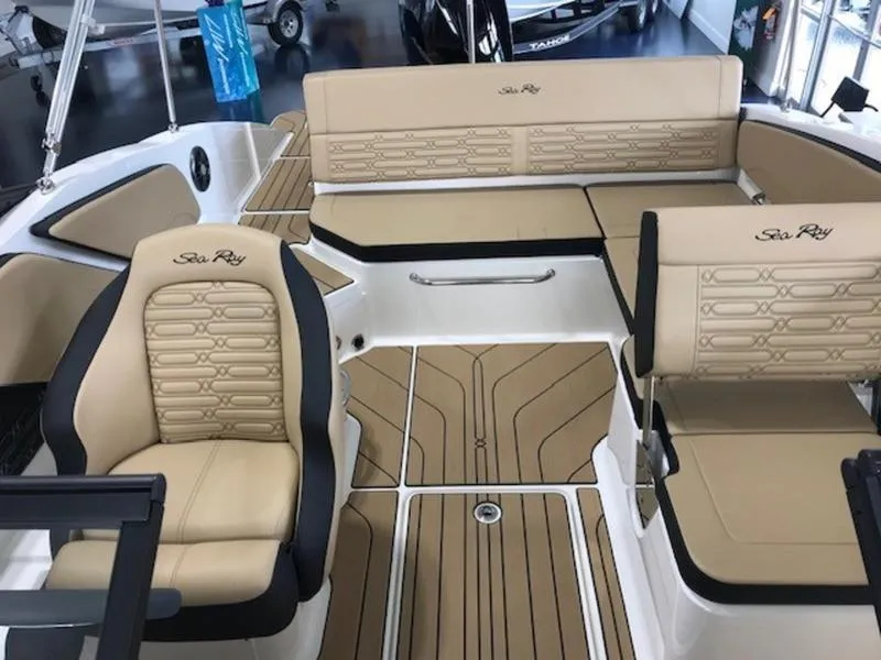 Slide: The Image of 2025 Sea Ray SPX 210 OB boat interior with beige seating and stylish design. - 11