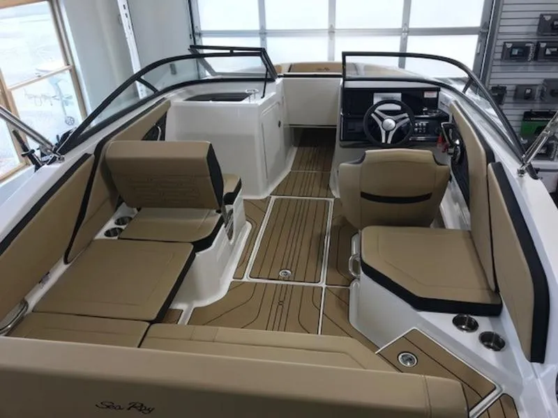 Slide: The Image of 2025 Sea Ray SPX 210 OB boat interior with tan seating and modern dashboard. - 6