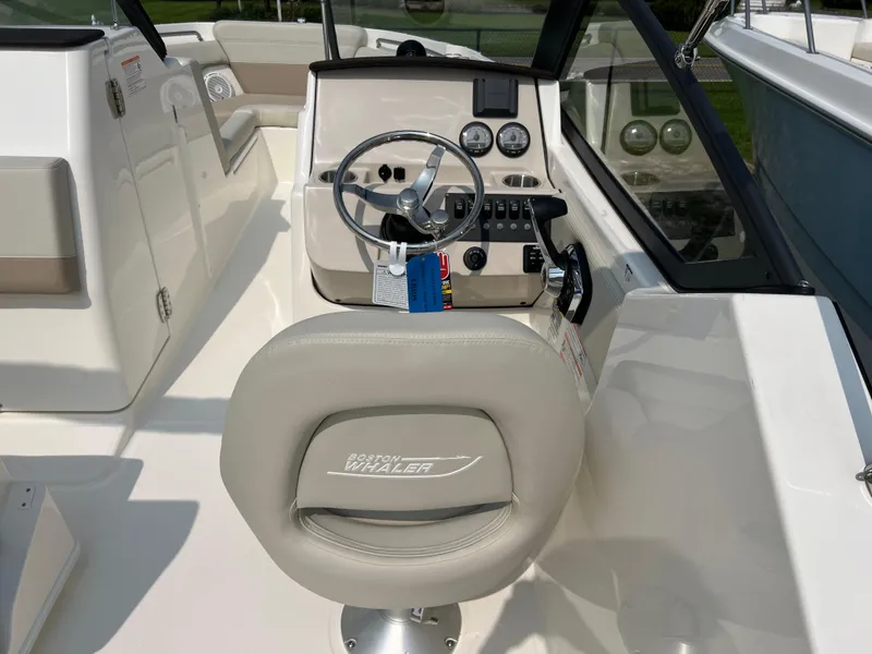 Slide: The Image of 2025 Boston Whaler 210 Vantage boat interior with steering wheel and dashboard controls. - 11