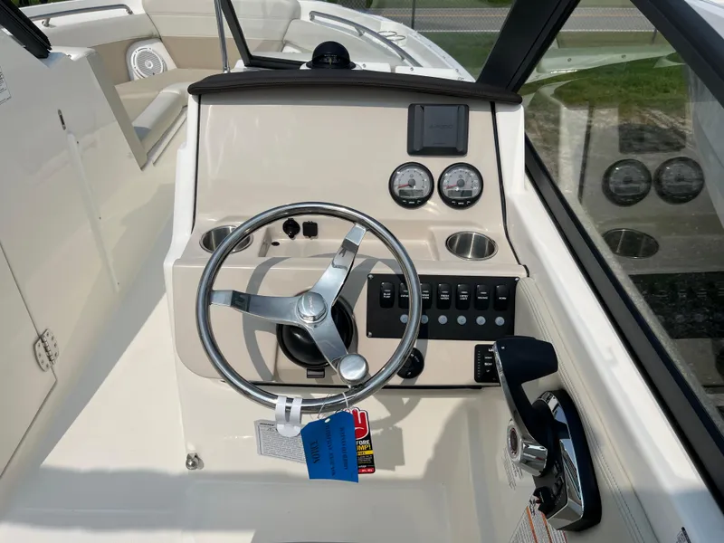 Slide: The Image of 2025 Boston Whaler 210 Vantage boat dashboard with steering wheel and control panel. - 12