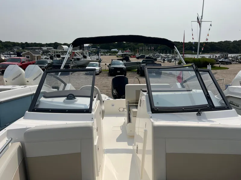 Slide: The Image of 2025 Boston Whaler 210 Vantage boat at marina, featuring dual consoles and open deck. - 14
