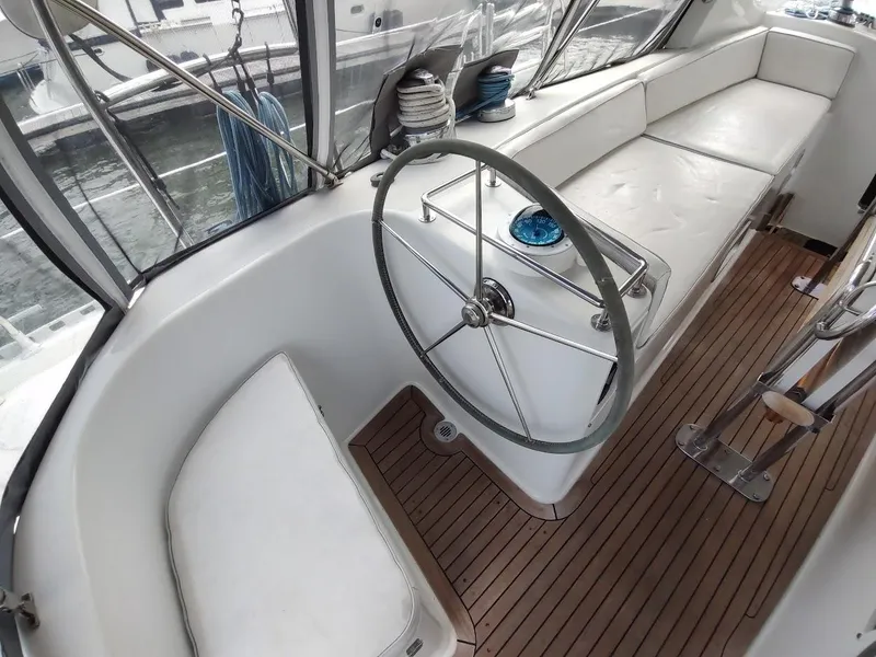 Slide: The Image of Stevens Custom 53/56 yacht cockpit with steering wheel, white seating, and wooden flooring, 2005 model. - 28