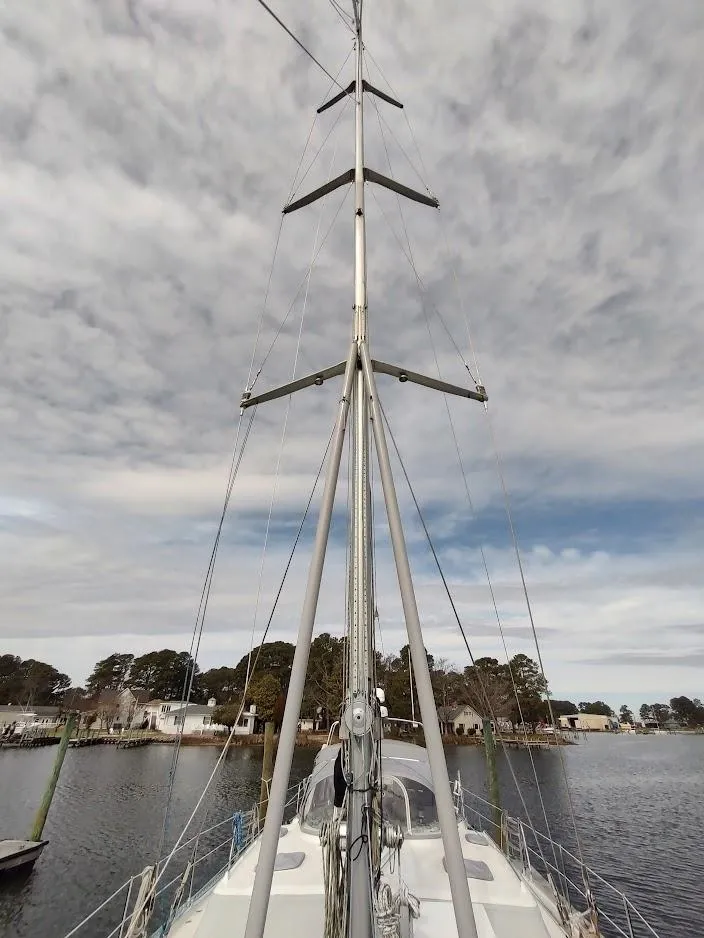 Slide: The Image of Sailboat mast of 2005 Stevens Custom 53/56 against cloudy sky, docked by waterfront homes. - 9