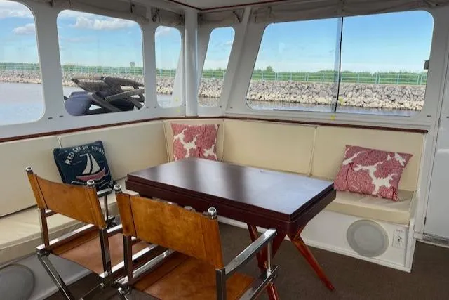 Slide: The Image of 1970 Huckins Offshore yacht interior with seating area and table. - 11