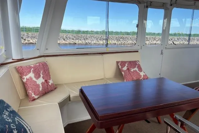 Slide: The Image of 1970 Huckins Offshore yacht interior with seating area and wooden table. - 12