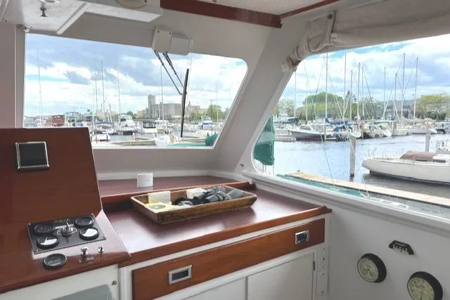 Slide: The Image of 1970 Huckins Offshore yacht interior with marina view through large windows. - 14