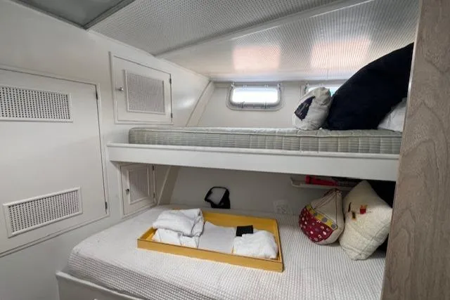 Slide: The Image of 1970 Huckins Offshore boat cabin with bunk beds and storage. - 22