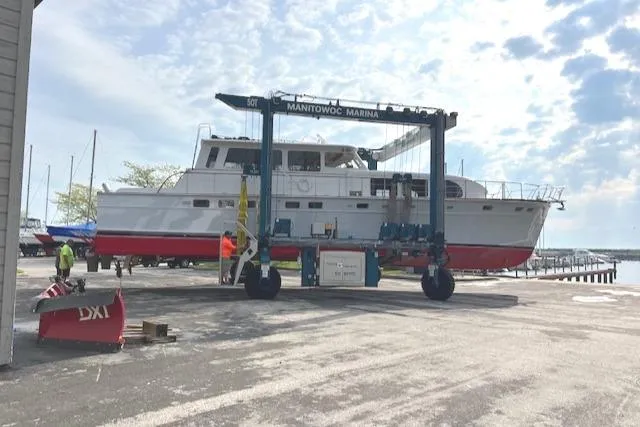 Slide: The Image of 1970 Huckins Offshore boat at Manitowoc Marina being lifted by a boat hoist. - 5