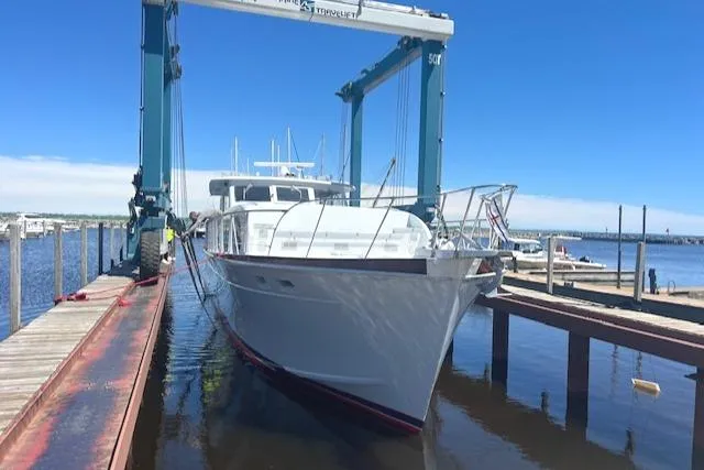 Slide: The Image of 1970 Huckins Offshore yacht being lifted at a marina. - 6