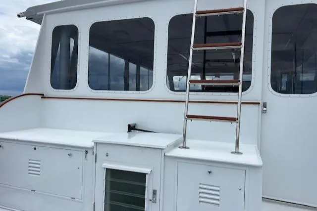 Slide: The Image of 1970 Huckins Offshore boat with white exterior and ladder. - 7