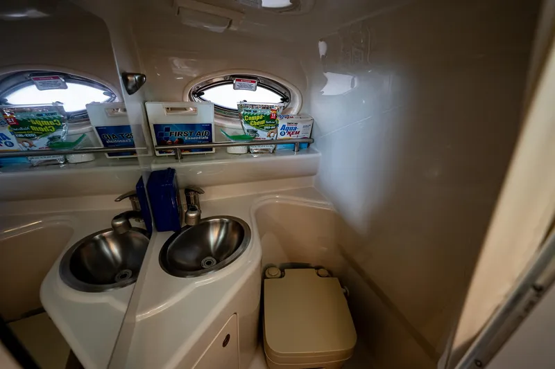 Slide: The Image of 2008 Sea Ray 240 Sundancer bathroom with dual sinks and compact toilet. - 12