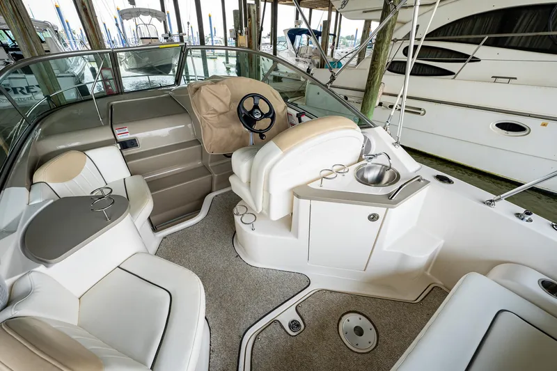 Slide: The Image of 2008 Sea Ray 240 Sundancer boat interior with helm, seating, and sink. - 6
