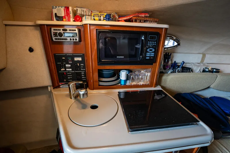 Slide: The Image of 2008 Sea Ray 240 Sundancer galley with microwave, sink, and stove. - 9