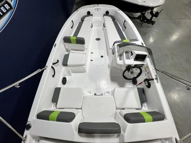 Slide: The Image of 2024 Tahoe T18 boat interior with gray and green seating, steering console, and spacious layout. - 19