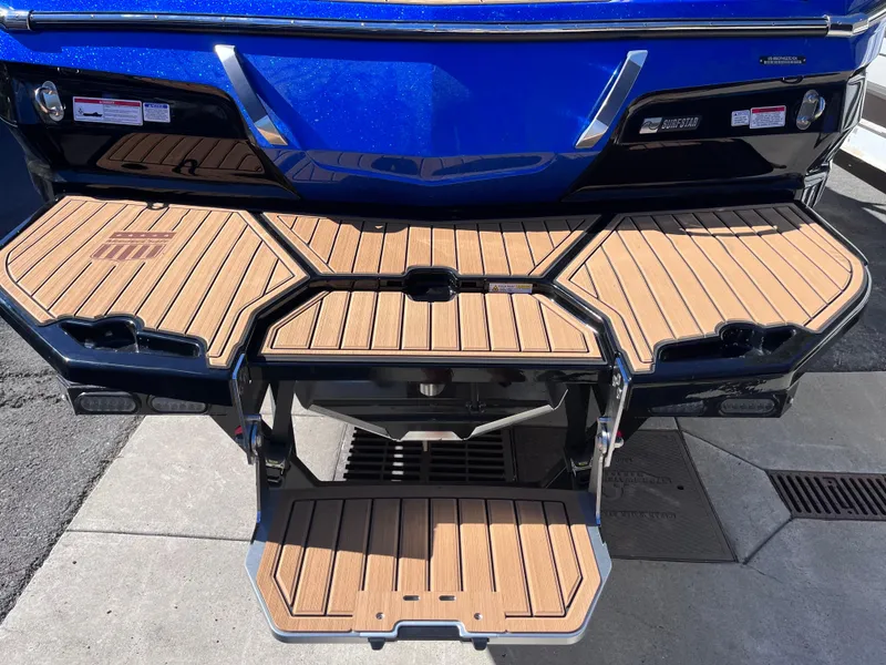 Slide: The Image of 2024 MasterCraft X24 boat with teak swim platform and blue hull. - 6