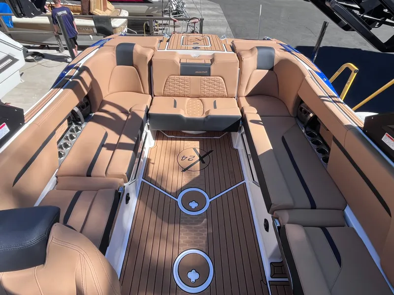 Slide: The Image of 2024 MasterCraft X24 boat interior with tan leather seating and teak flooring. - 8