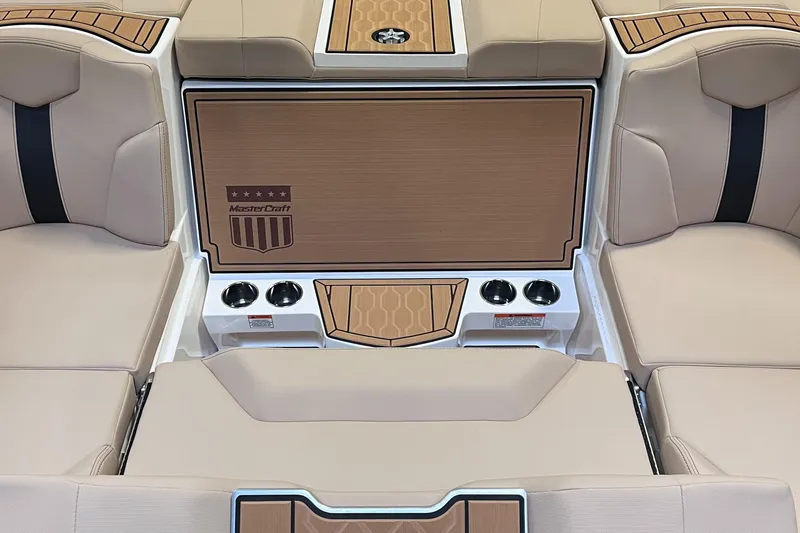 Slide: The Image of 2024 MasterCraft XT23 boat interior with beige seating and cup holders. - 13