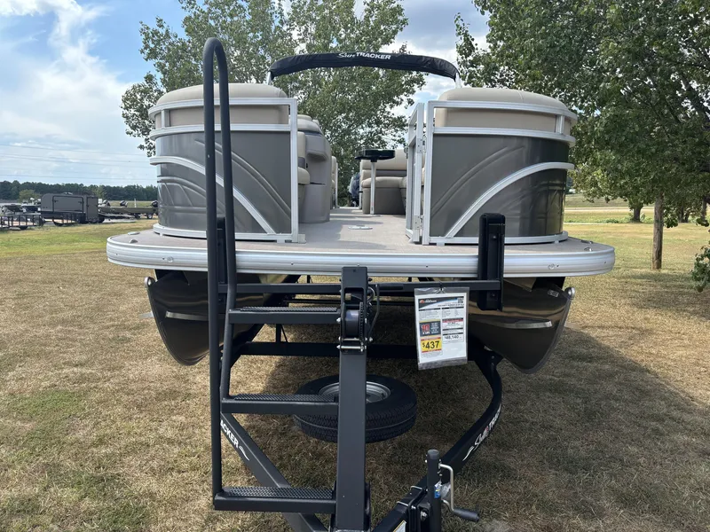 Slide: The Image of 2024 Sun Tracker Party Barge 22 RF DLX pontoon boat on trailer, parked on grass. - 12
