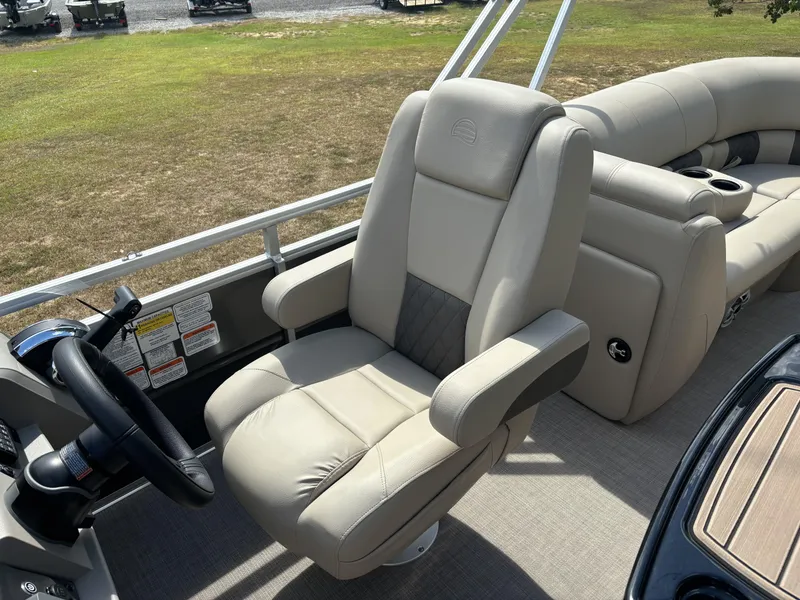 Slide: The Image of 2024 Sun Tracker Party Barge 22 RF DLX captain's chair and helm, showcasing luxury seating. - 14