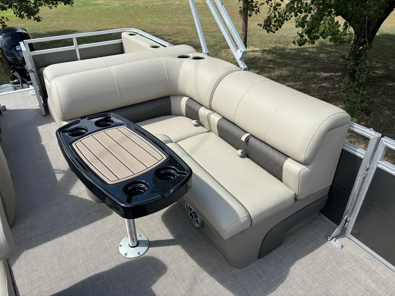 Slide: The Image of 2024 Sun Tracker Party Barge 22 RF DLX interior with beige seating and table. - 6