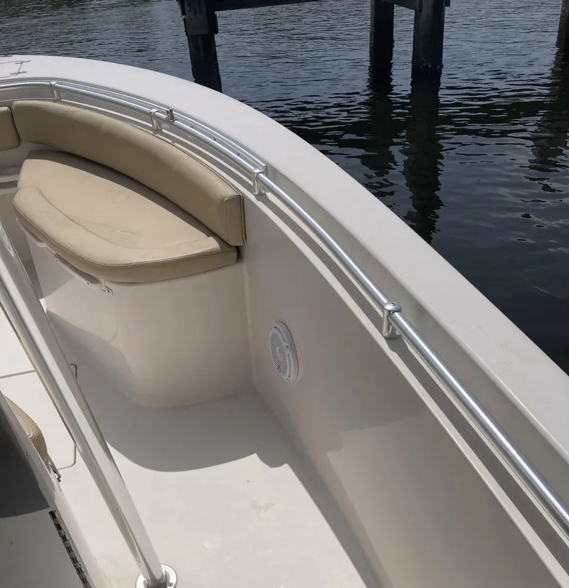 Slide: The Image of 2008 Cobia 256 Center Console boat with cushioned seating by the water. - 14
