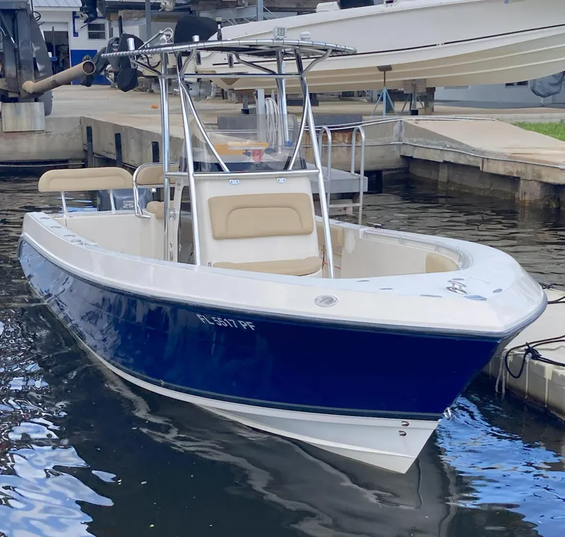 Slide: The Image of 2008 Cobia 256 Center Console boat docked at a marina. - 2